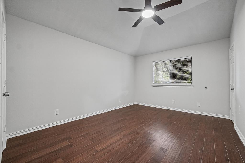 Vaulted ceilings, wood-finish flooring, and a central ceiling fan with integrated lighting