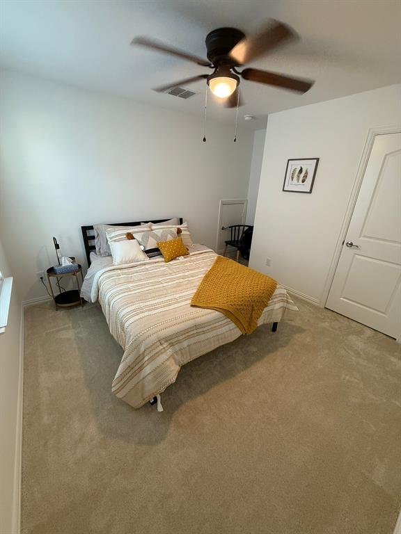 Carpeted bedroom with a ceiling fan and baseboards