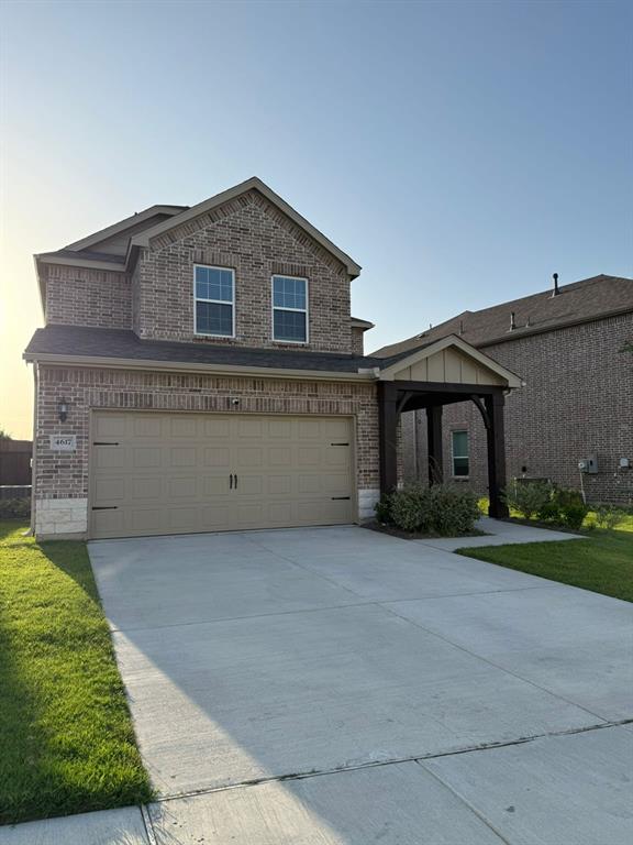View of front facade featuring brick siding, concrete driveway, and an attached garage