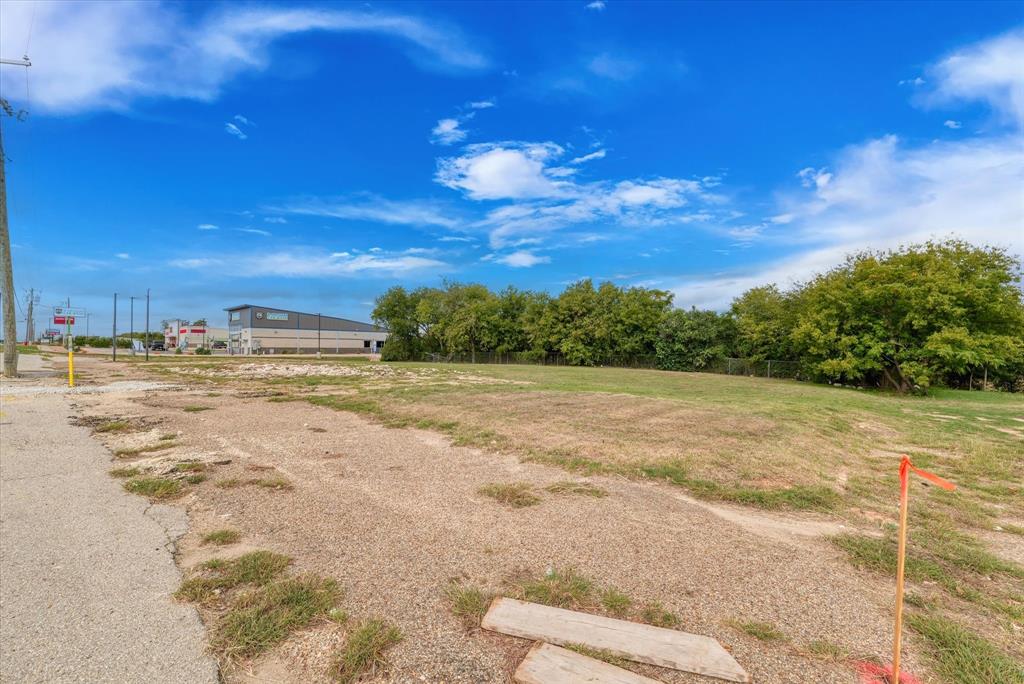 Cleared parcel of land featuring open grass area and perimeter tree line