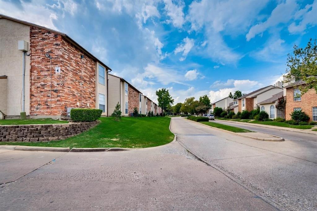 Exterior featuring multi-story brick and siding facades, concrete roadway, retained landscaping, and manicured green space Exterior featuring multi-story brick and siding facades, concrete roadway, retained landscaping, and manicured green space