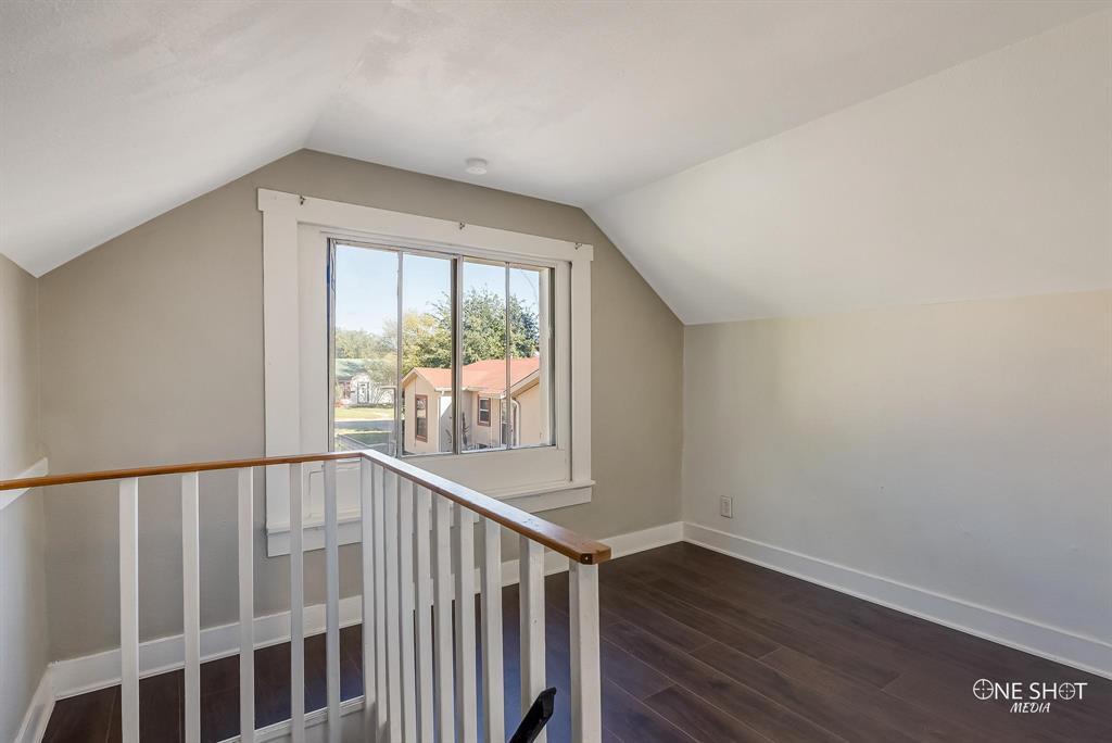 Additional living space with dark hardwood / wood-style flooring and lofted ceiling