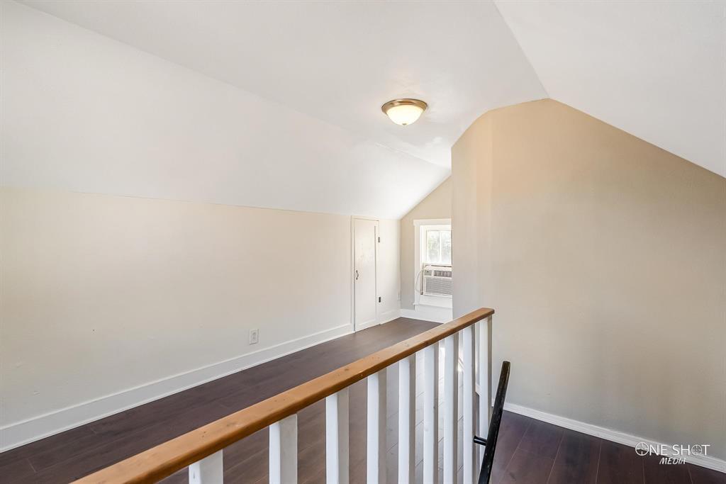Corridor featuring cooling unit, dark hardwood / wood-style floors, and vaulted ceiling
