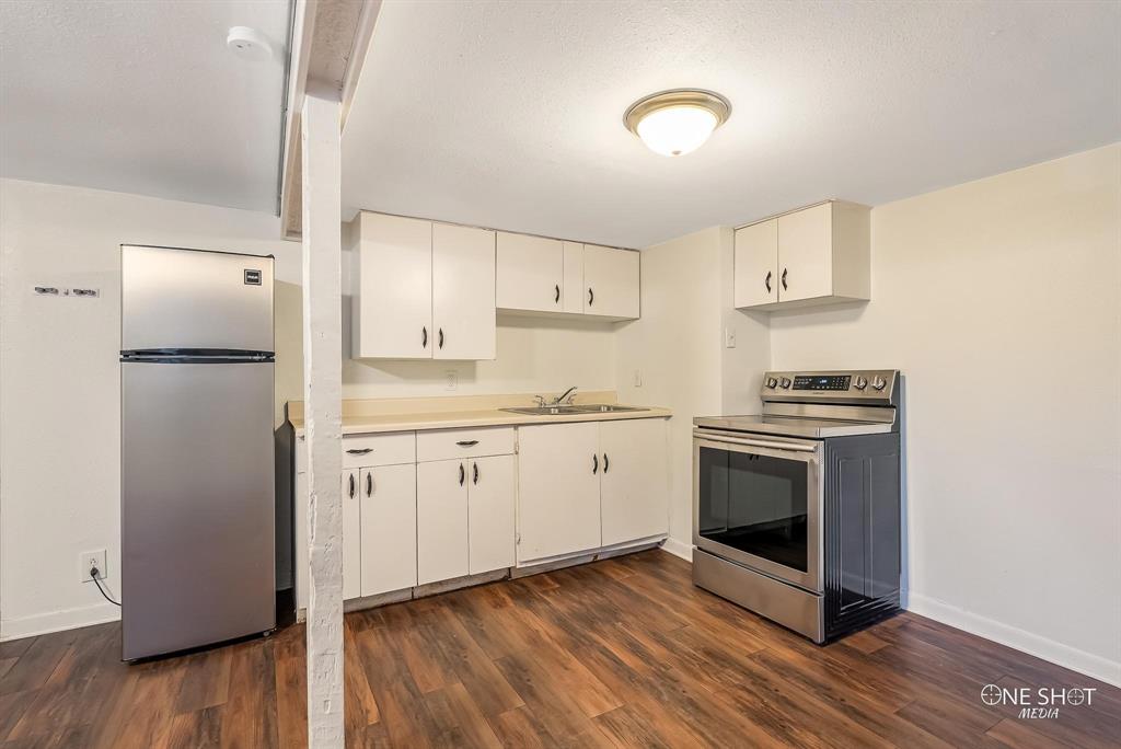 Kitchen featuring sink, white cabinets, dark hardwood / wood-style flooring, and stainless steel appliances