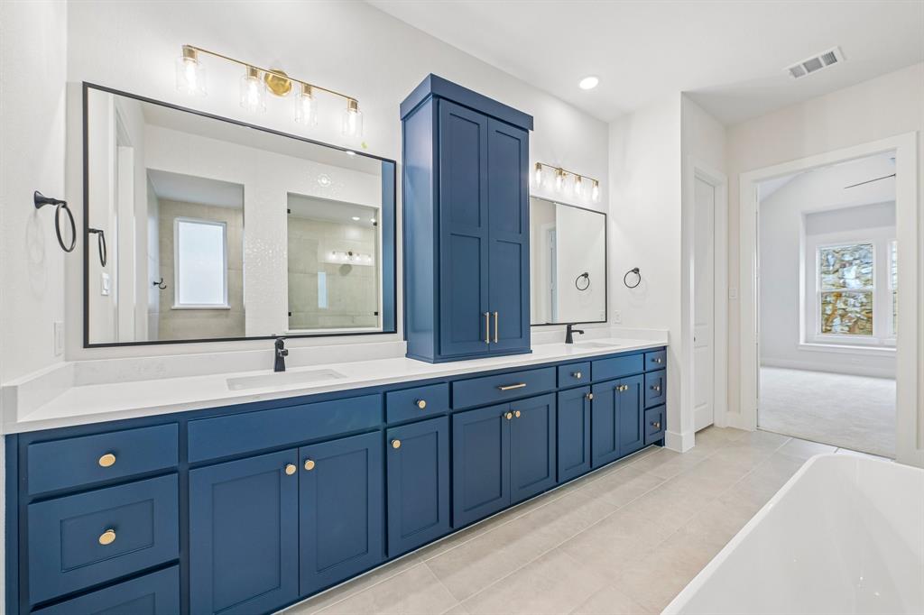 Featuring vibrant cabinetry that is as functional as it is beautiful, this owner's bath is a dream come true!