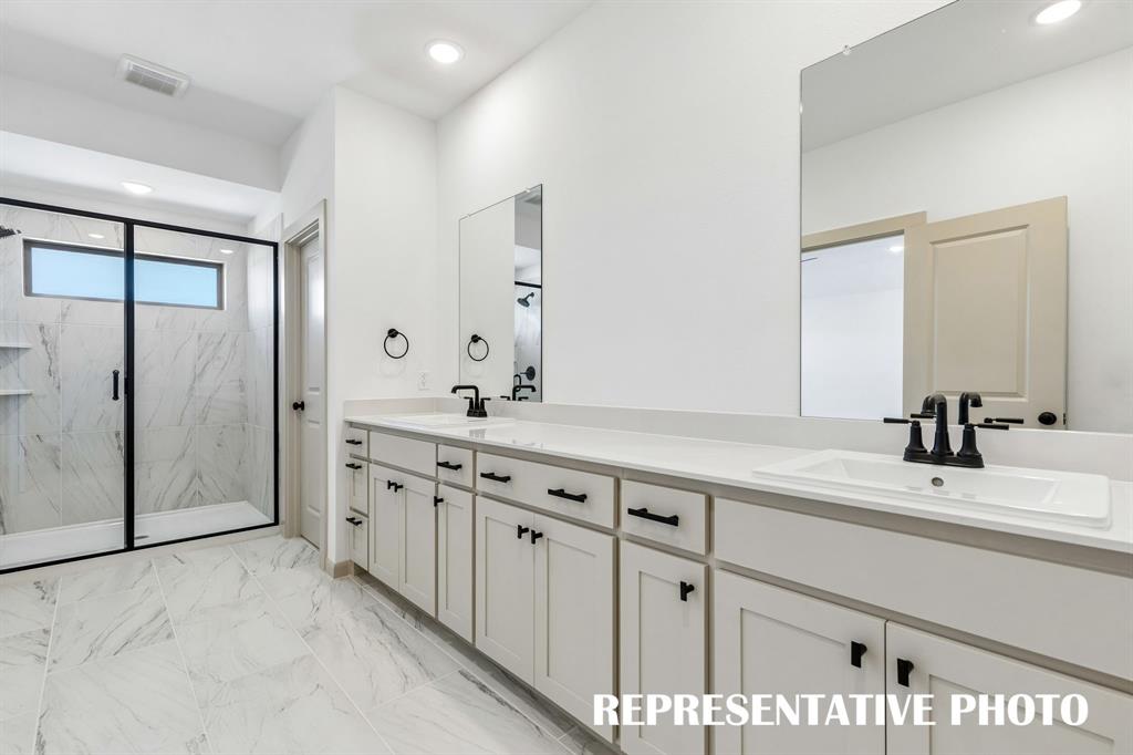 With ample room for two and a lovely walk in shower, this owner's bath is a dream come true!  REPRESENTATIVE PHOTO