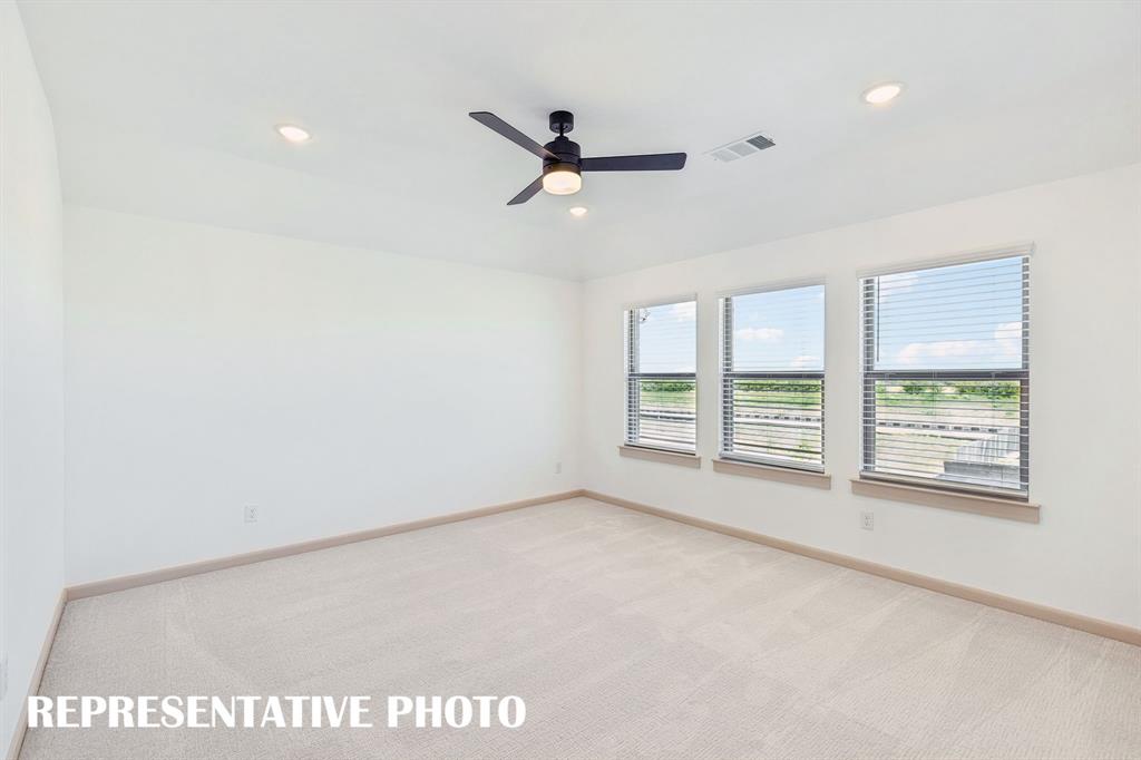 Featuring plush carpeting and a wall of windows, this wonderful owner's suite was designed for rest and relaxation.  REPRESENTATIVE PHOTO
