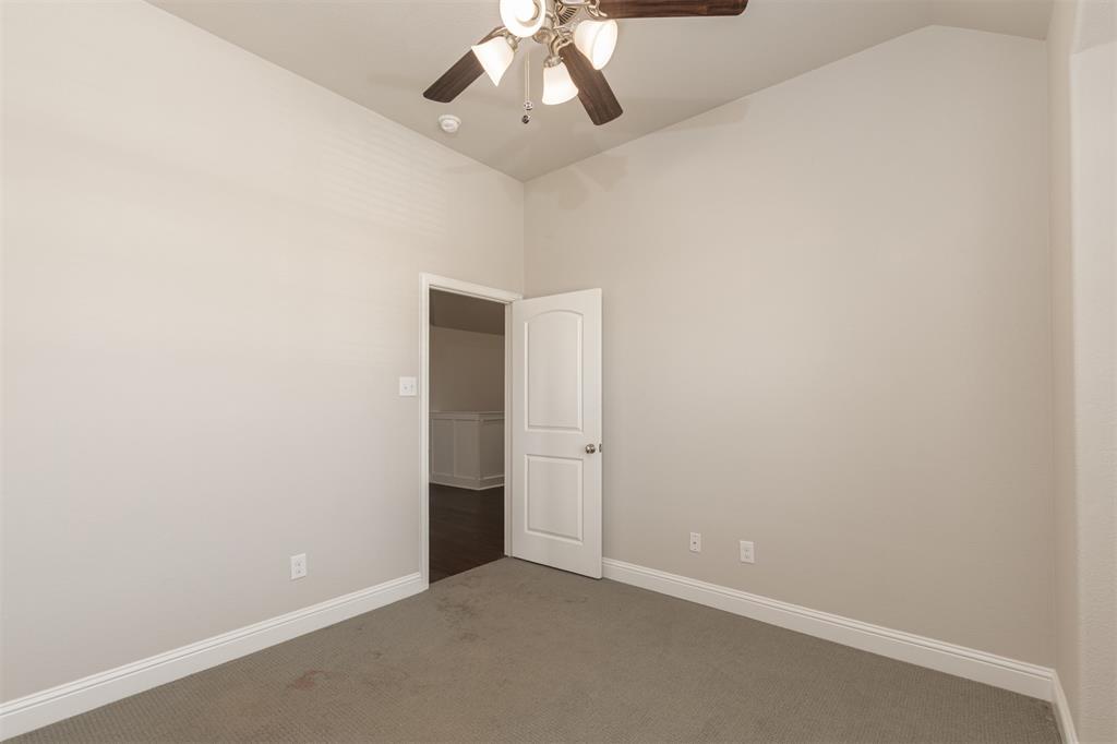 Vaulted ceilings, neutral wall tones, carpeted flooring, and a multi-blade ceiling fan with integrated lighting