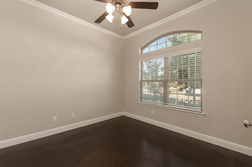 Room featuring high ceilings with crown molding, dark wood-finish flooring, and an arched transom window Room featuring high ceilings with crown molding, dark wood-finish flooring, and an arched transom window