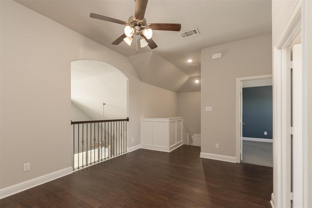 Wood-finish flooring, vaulted ceiling, metal baluster railing, recessed lighting, and a multi-light ceiling fan