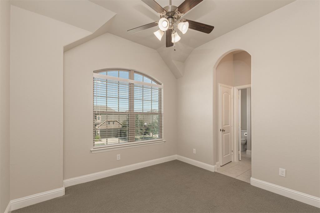 Vaulted ceilings with an arched window, neutral wall palette, ceiling fan with integrated lighting, and a prominent arched entryway