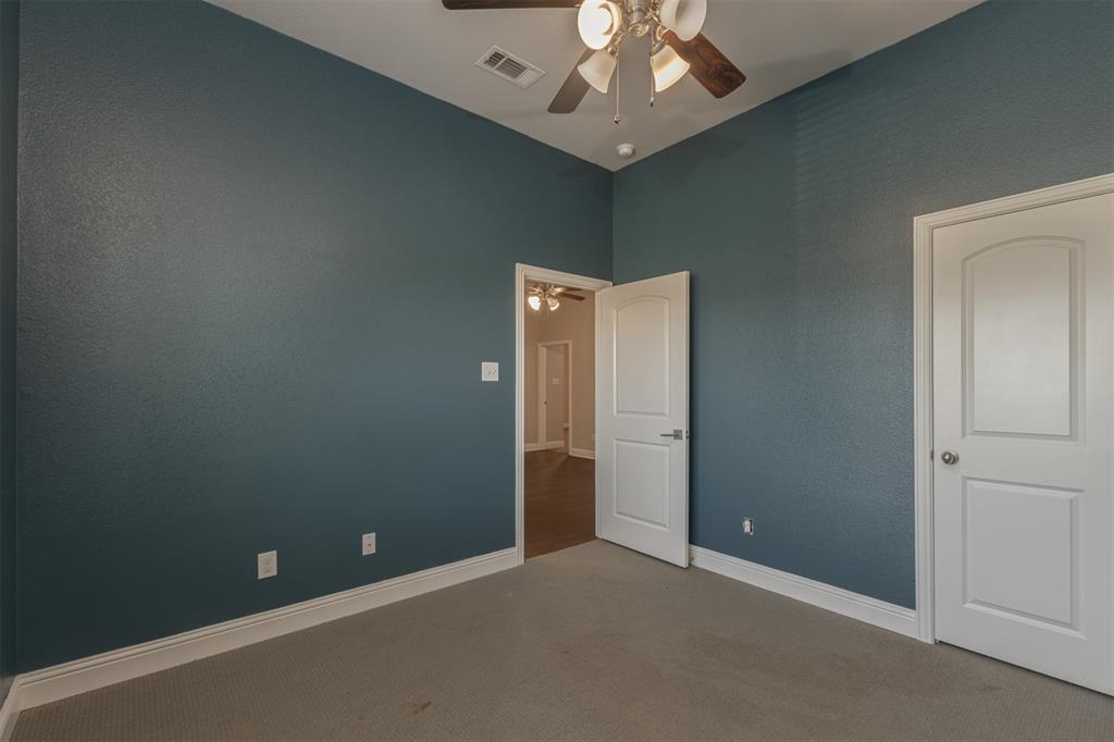 Interior room featuring high ceilings, neutral carpeting, and a ceiling fan with integrated lighting