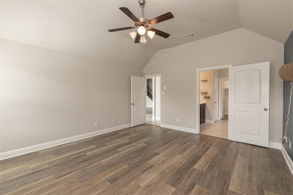 Vaulted ceilings, wood-finish flooring, and a multi-light ceiling fan with integrated illumination