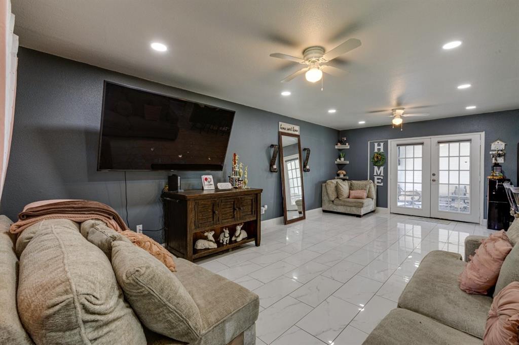 Polished tile flooring, recessed ceiling lighting, dual ceiling fans, and French doors featuring glass panes
