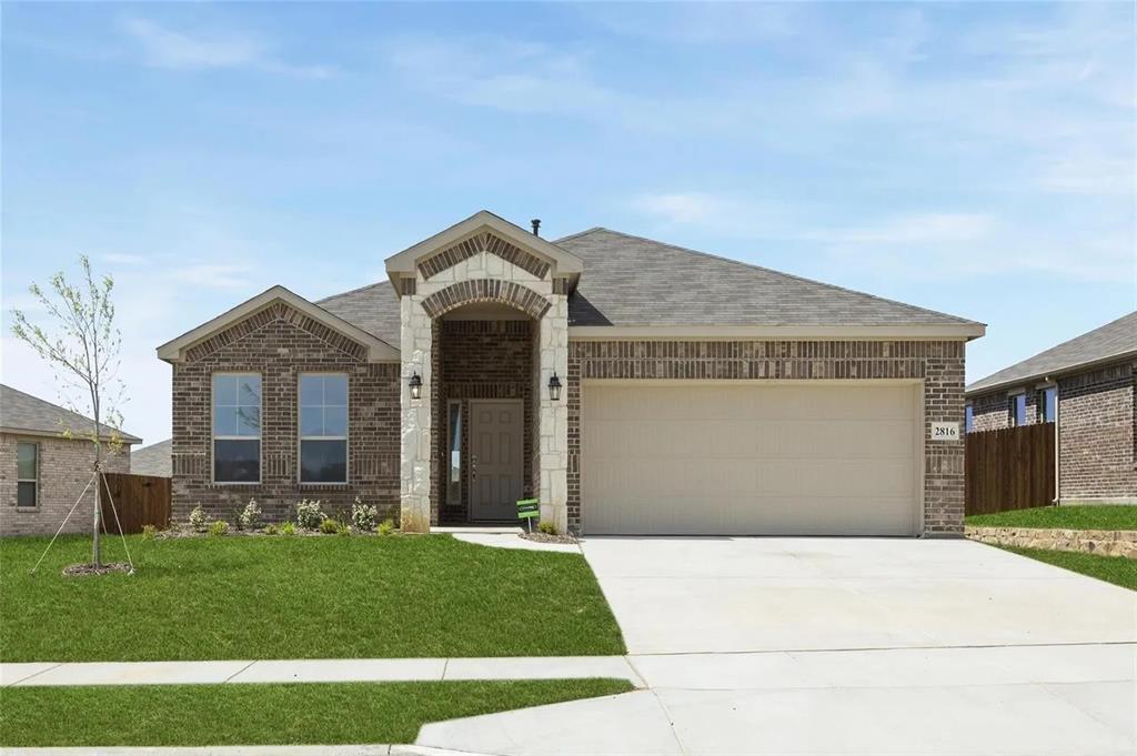 Single-story exterior featuring a brick and stone facade, arched entryway, and two-car garage Single-story exterior featuring a brick and stone facade, arched entryway, and two-car garage