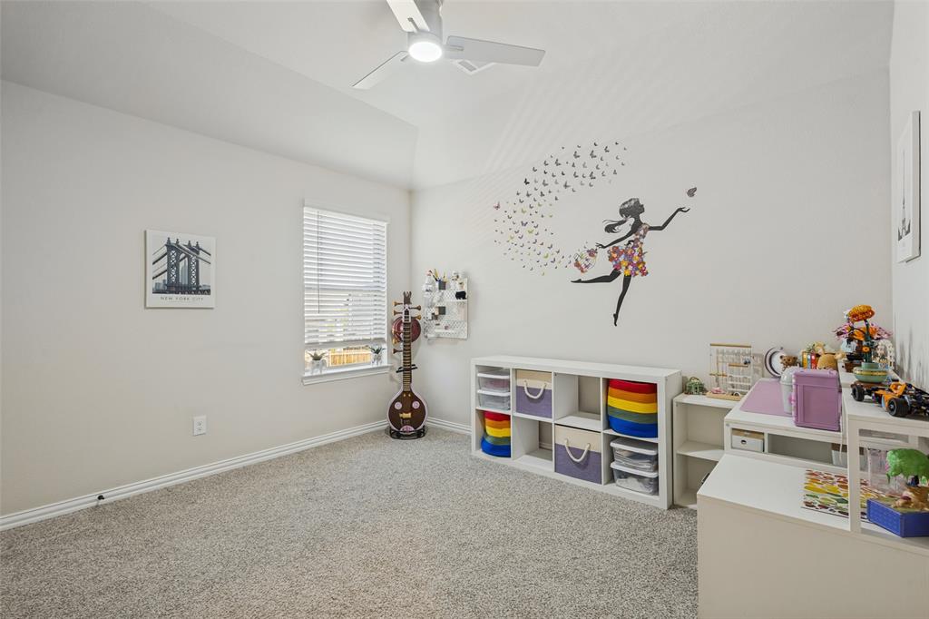 Room featuring a vaulted ceiling, neutral wall tones, wall-to-wall carpeting, a window with horizontal blinds, and a white ceiling fan with integrated lighting