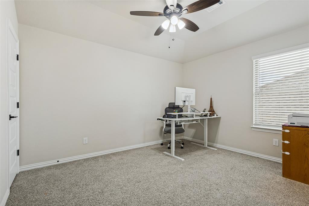 Room featuring neutral wall tones, carpeted flooring, a tray ceiling, a multi-blade ceiling fan with integrated lighting, and a window with horizontal blinds