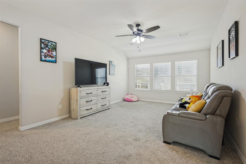 Vaulted ceilings featuring a ceiling fan with integrated lighting and three windows equipped with horizontal blinds
