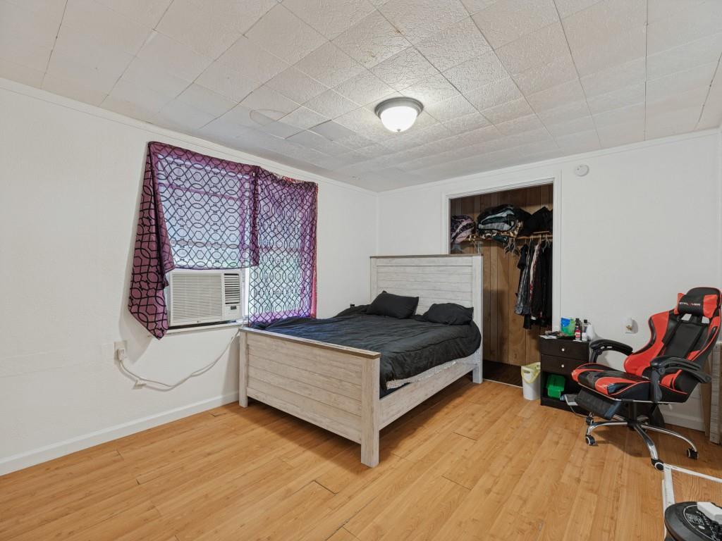 Interior space featuring wood-finish flooring, a textured ceiling, a central ceiling-mounted light fixture, and a built-in closet