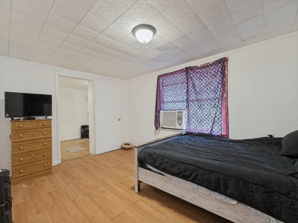 Wood-finish flooring, ceiling-mounted flush lighting, and a drop ceiling