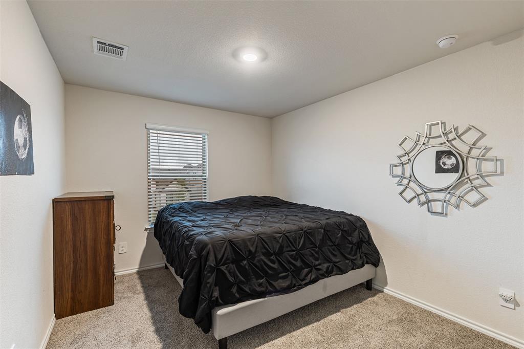 Neutral-toned interior space featuring wall-to-wall carpeting, a window with horizontal blinds, and recessed ceiling lighting