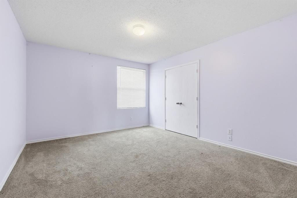 Interior room featuring wall-to-wall carpeting, a dual-door closet, a single-pane window with integrated blinds, and a central ceiling-mounted light fixture