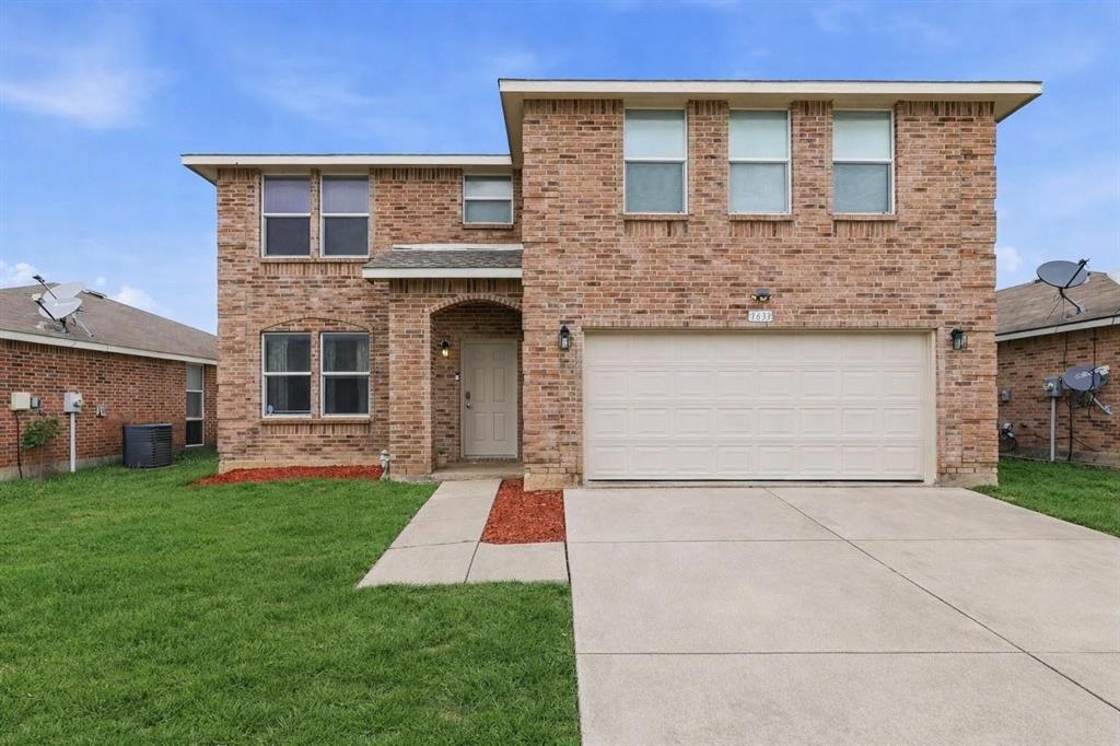 Two-story brick exterior featuring a multi-gabled roofline, double-car garage, concrete driveway, and recessed entryway