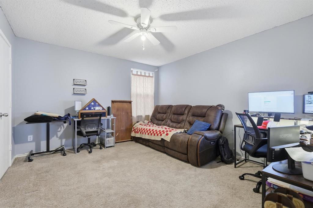 Neutral-toned interior space featuring wall-to-wall carpeting and a ceiling-mounted light fixture with a multi-blade fan