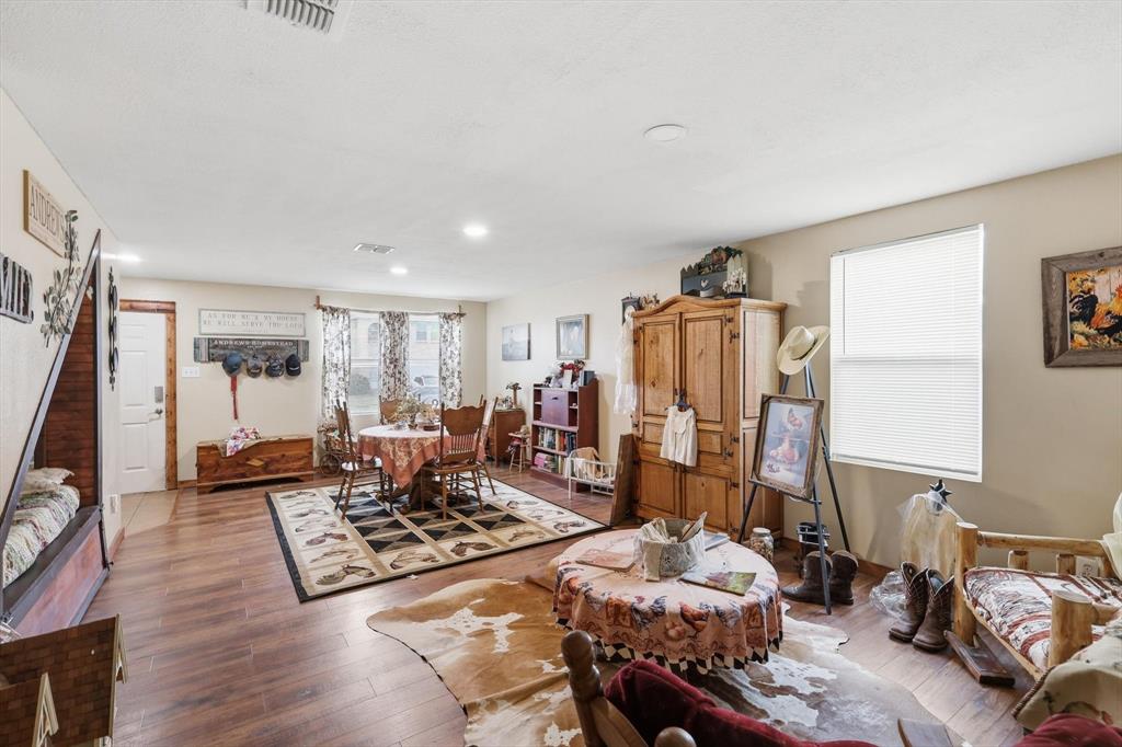 Open-concept interior featuring wood-finish flooring, recessed lighting, and windows with natural light