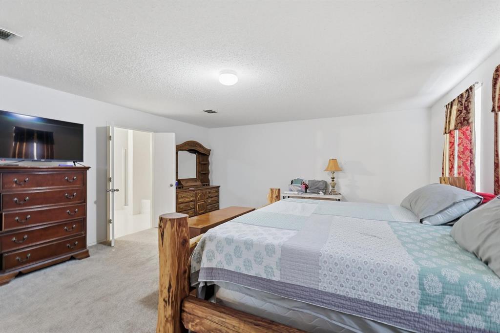 Neutral-toned carpet, textured ceiling, and double-door entry