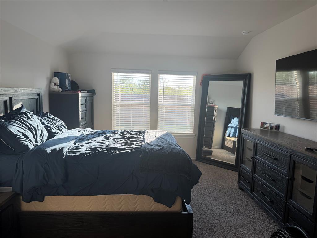 Bedroom featuring neutral wall paint, high ceilings, carpeting, and two windows with horizontal blinds Bedroom featuring neutral wall paint, high ceilings, carpeting, and two windows with horizontal blinds