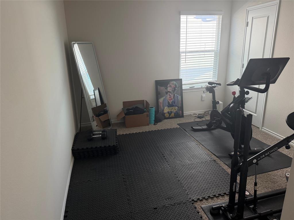Neutral interior room featuring carpeted flooring, a single-panel interior door, and a window with blinds Neutral interior room featuring carpeted flooring, a single-panel interior door, and a window with blinds