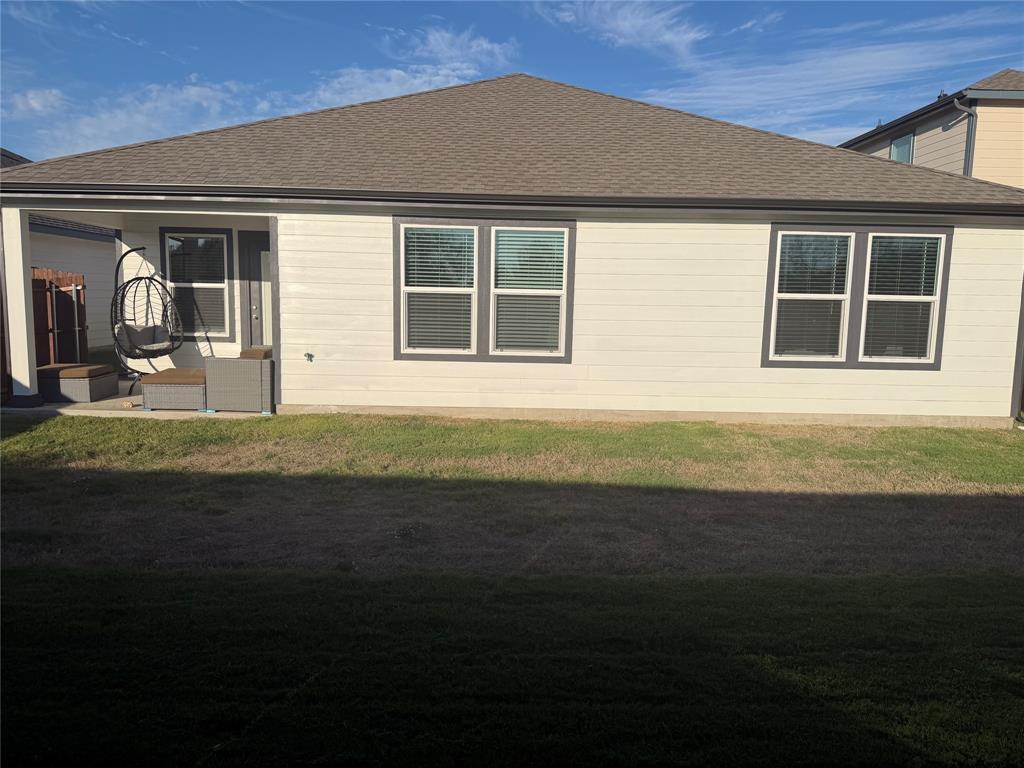 Exterior rear elevation featuring horizontal siding, a covered patio with concrete flooring, and a hip roof Exterior rear elevation featuring horizontal siding, a covered patio with concrete flooring, and a hip roof