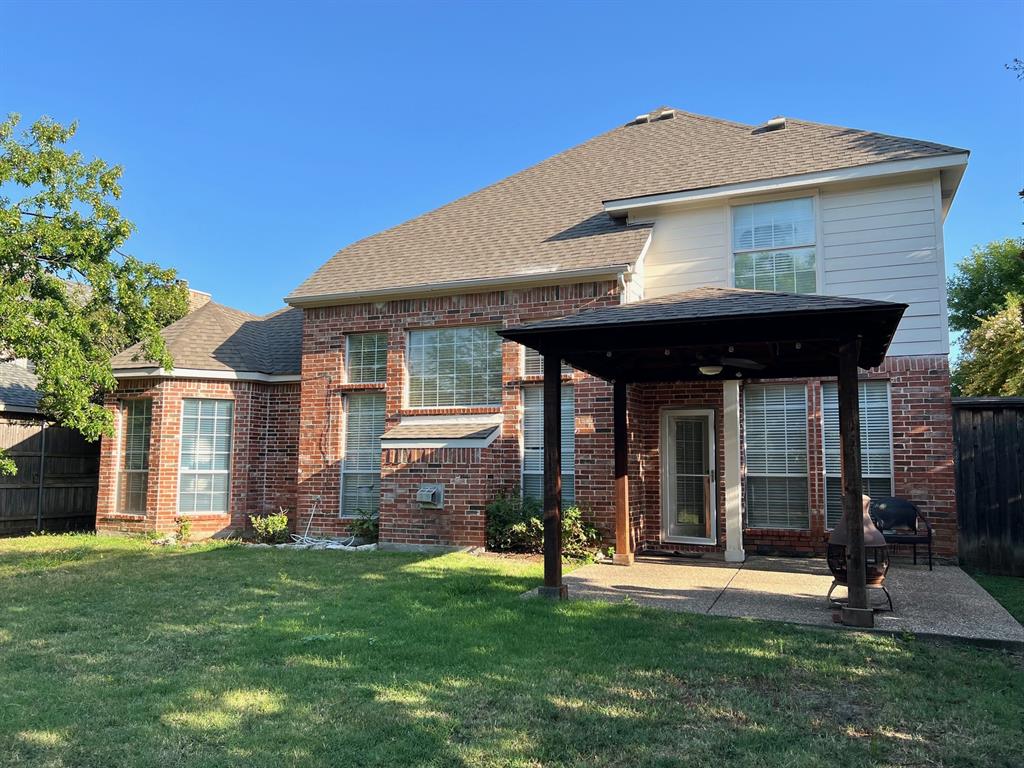Brick exterior residence featuring a covered patio, pergola, concrete hardscaping, and multi-pane windows