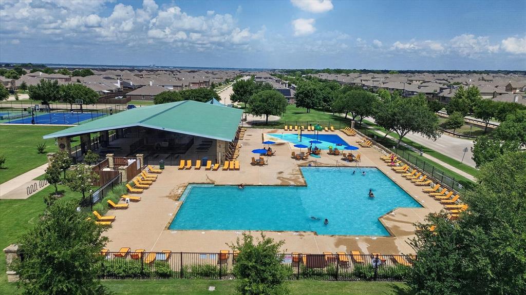 Community amenity center featuring a swimming pool, splash pad, shaded pavilion, and tennis courts