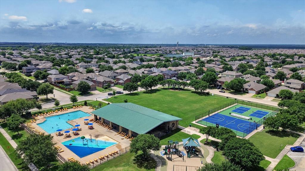 Community recreational complex featuring a swimming pool, children's splash pad, covered pavilion, hard-surface basketball court, and playground equipment