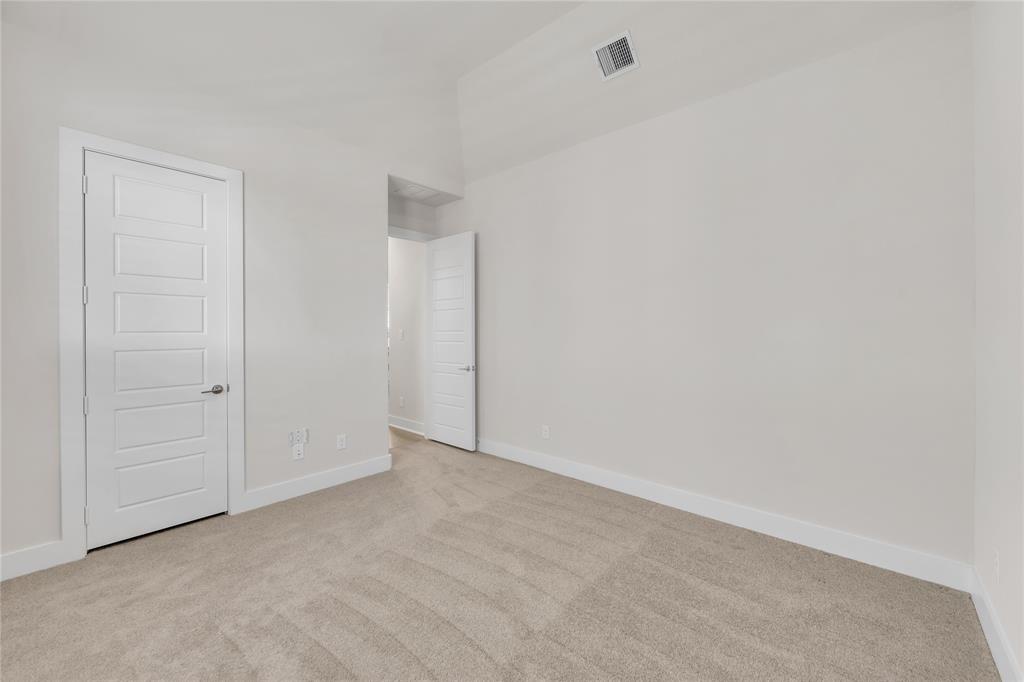 Room featuring vaulted ceilings, neutral-toned carpeting, and five-panel interior doors with brushed nickel hardware