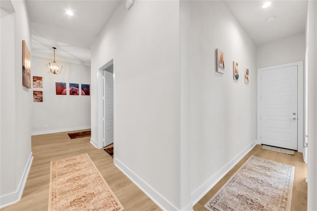 Foyer featuring wood-finish flooring, recessed lighting, a multi-panel entry door, and a geometric pendant light fixture
