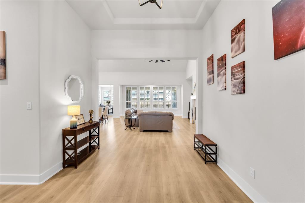 Entryway featuring wood-finish flooring, a tray ceiling, and neutral wall tones