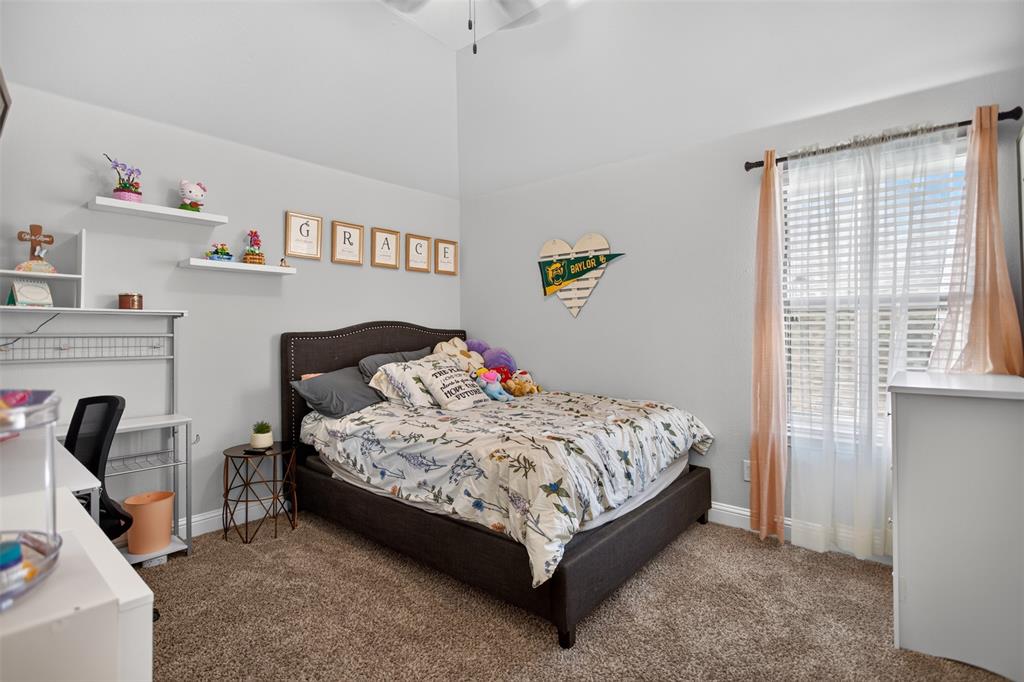 High ceilings with architectural volume, wall-mounted floating shelving, and carpeted flooring