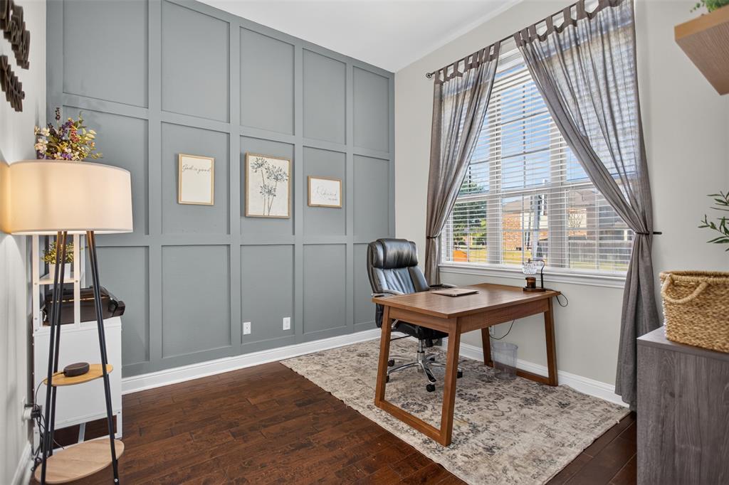 Full-height wood paneling, dark-tone wood-finish flooring, and large window with blinds