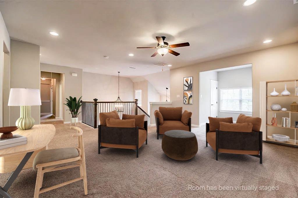 Open floor plan featuring recessed lighting, a ceiling fan, wall-to-wall carpeting, and a staircase with a wooden handrail and metal balusters