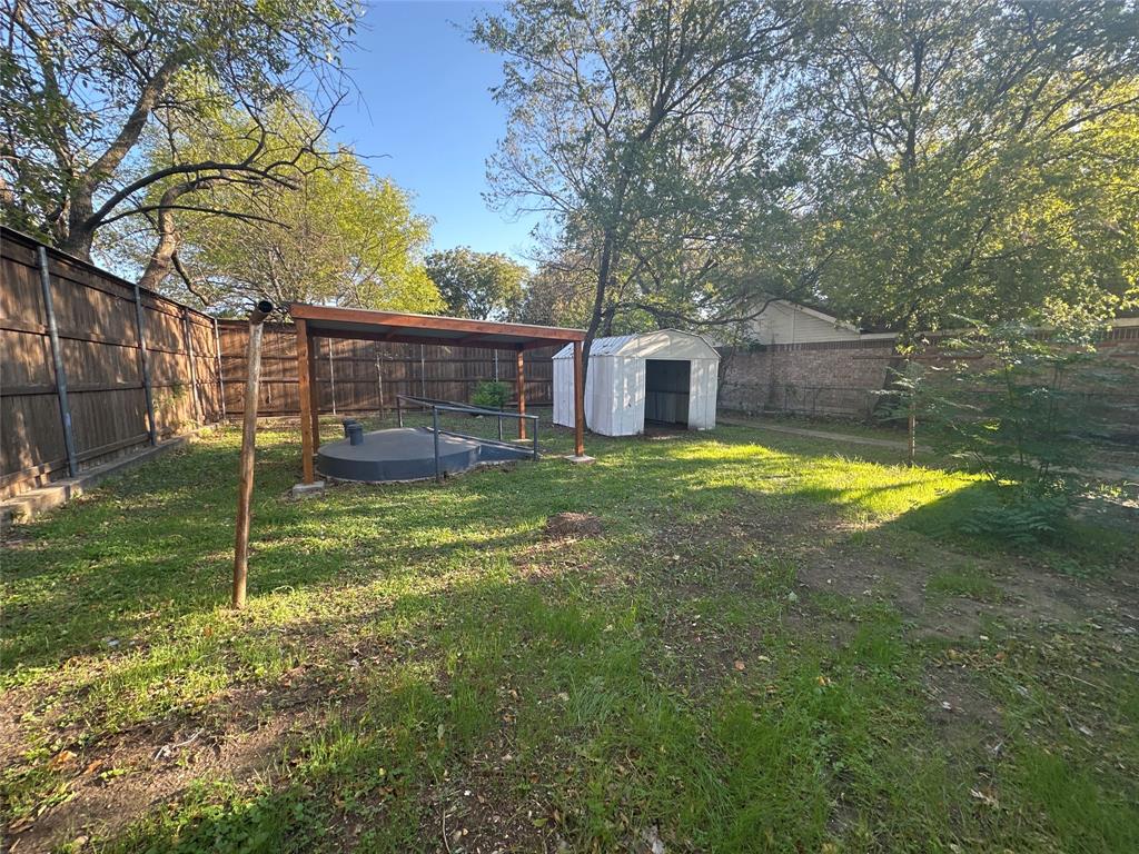 Backyard featuring a storm shelter and a detached metal storage shed