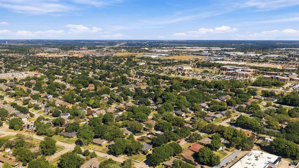 Aerial perspective of an established neighborhood featuring mature tree canopy, dense residential landscaping, and proximity to regional commercial infrastructure