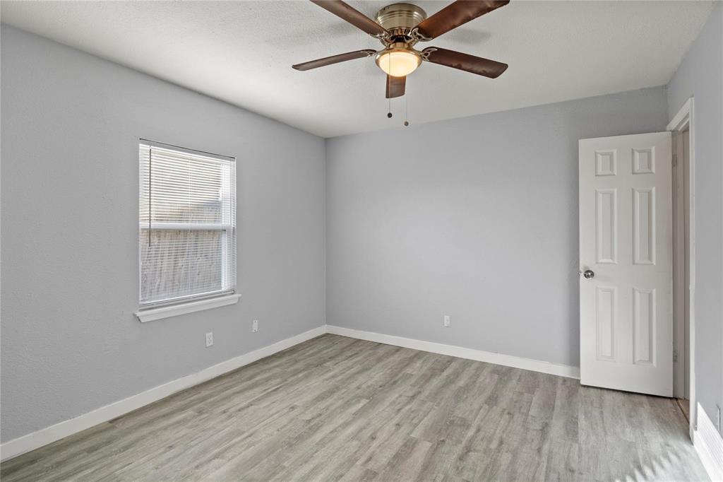Neutral-toned interior featuring wood-finish flooring, a ceiling fan with integrated lighting