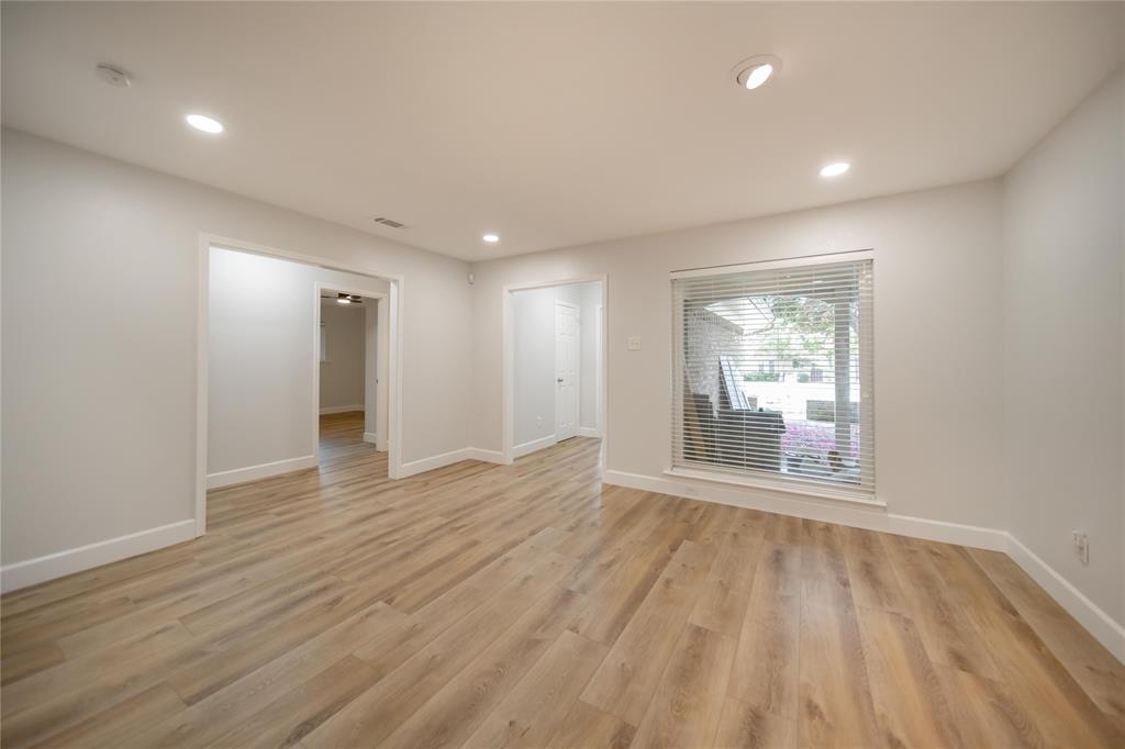 Interior space featuring wood-finish flooring, recessed lighting, and a large window with horizontal blinds Interior space featuring wood-finish flooring, recessed lighting, and a large window with horizontal blinds