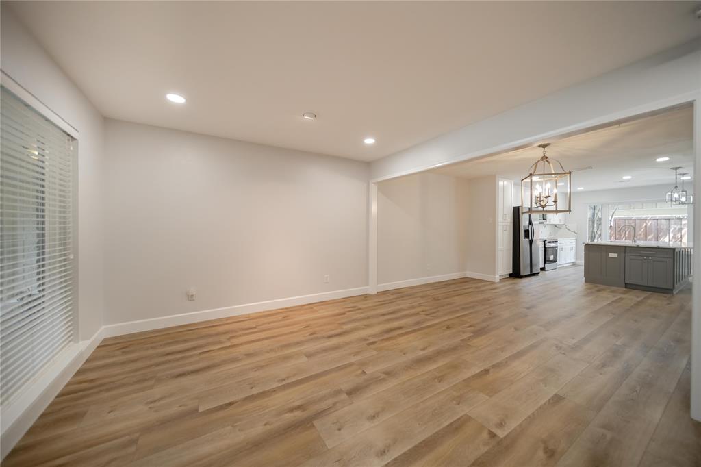 Neutral interior featuring wood-finish flooring, recessed lighting, and a suspended metal lantern fixture Neutral interior featuring wood-finish flooring, recessed lighting, and a suspended metal lantern fixture