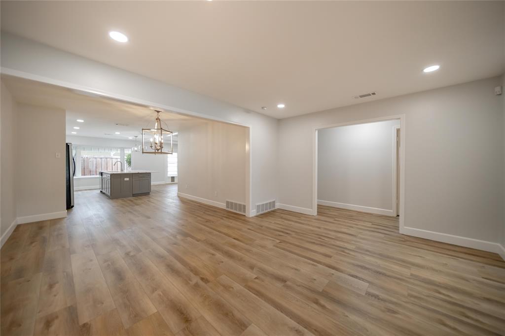 Open floor plan featuring wood-finish flooring, recessed lighting, and a metal lantern-style chandelier Open floor plan featuring wood-finish flooring, recessed lighting, and a metal lantern-style chandelier