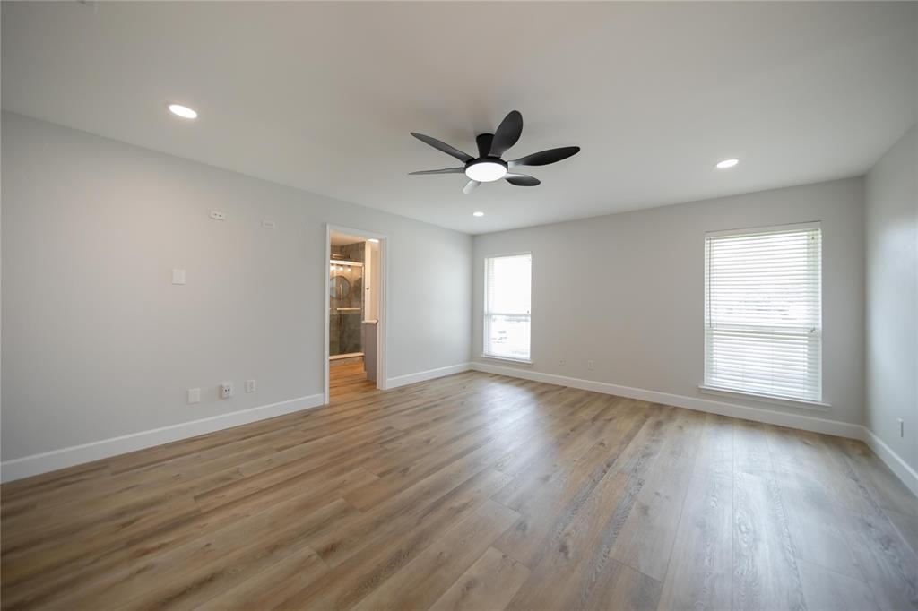 Room featuring wood-finish flooring, recessed lighting, matte black ceiling fan with integrated lighting, and dual windows with horizontal blinds