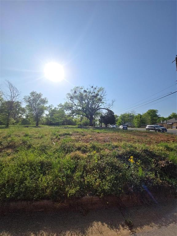 Vacant lot featuring cleared terrain, native ground cover, and mature trees